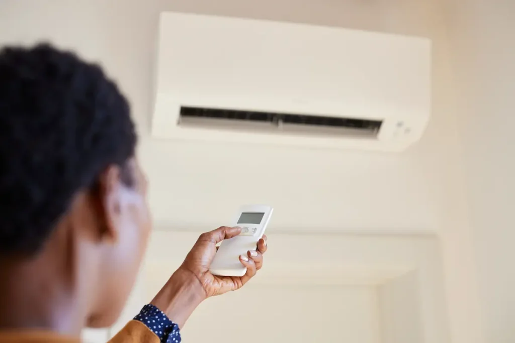 A woman holding remote control air conditioning