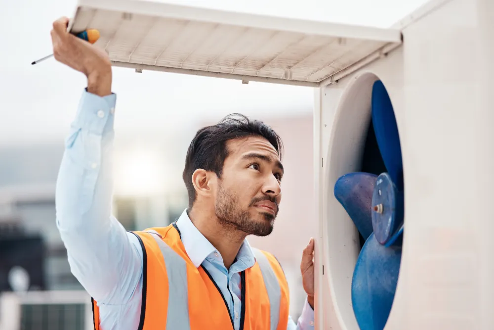 HVAC technician doing maintenance on an HVAC unit.