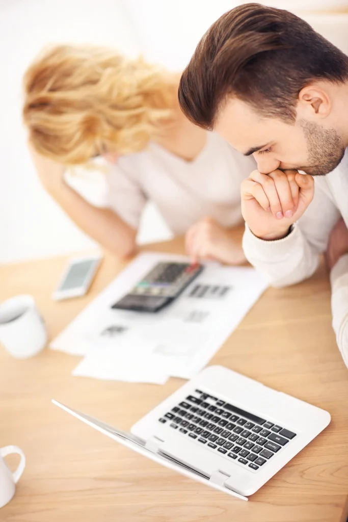 Worried couple with documents at home