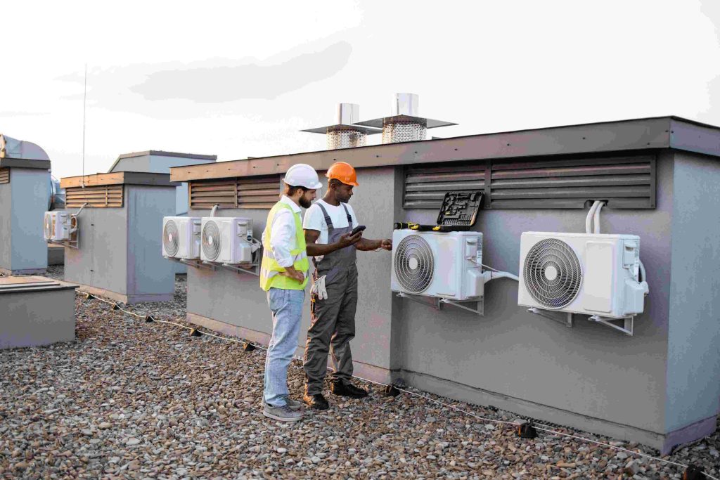 two-construction-workers-on-roof-inspecting-coolin