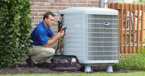 Technician in blue shirt repairs outdoor air conditioning unit beside brick wall